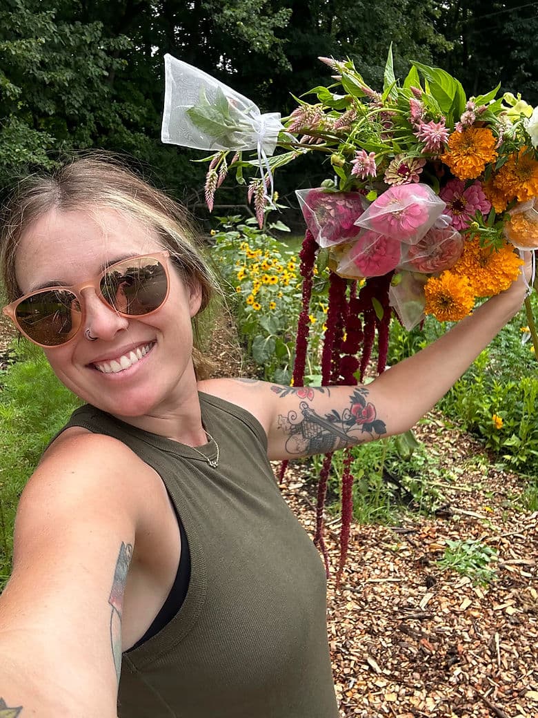 Kate in her flower garden holding farm fresh flowers